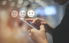 Business woman use mobilepressing smiley face touch screen