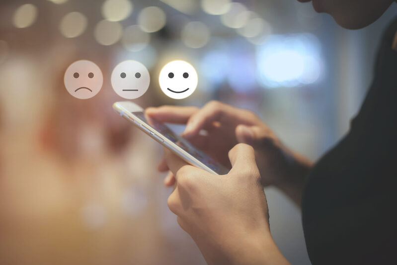 Business woman use mobilepressing smiley face touch screen