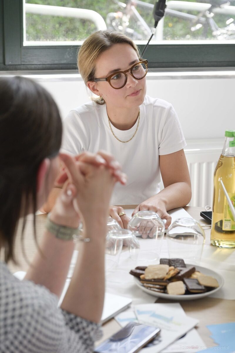 Frau im Gespräch am Tisch sitzend