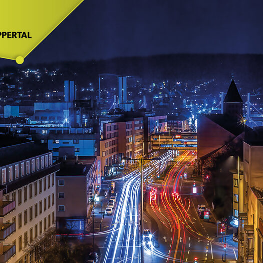 Ein Bild der Talachse bei Nacht und das Logo SMART.WUPPERTAL
